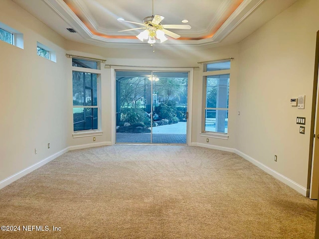 unfurnished room with light carpet, a raised ceiling, ceiling fan, and crown molding