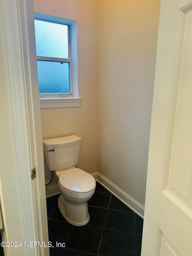 bathroom with toilet and tile patterned floors