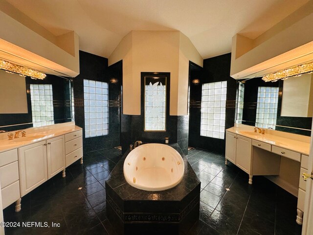 bathroom featuring a bathing tub, vanity, tile walls, and tile patterned floors