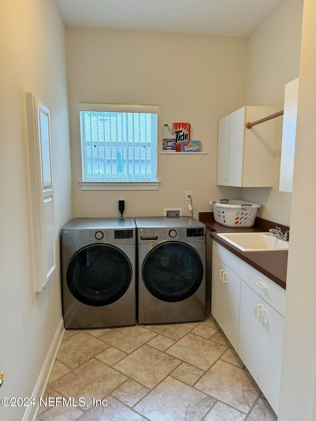 laundry room featuring separate washer and dryer, sink, and cabinets