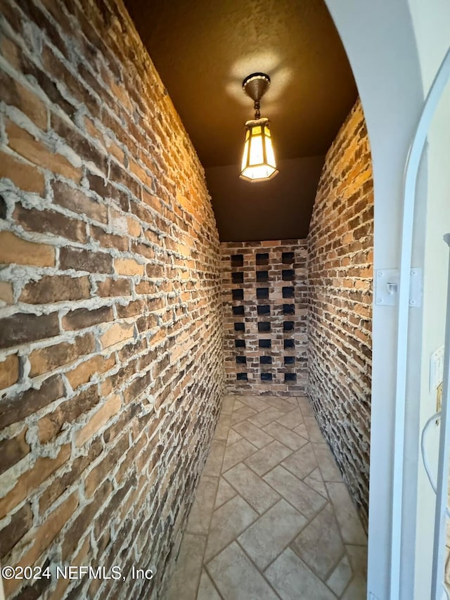 wine cellar featuring lofted ceiling and brick wall