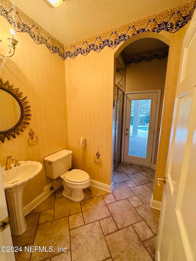 bathroom with a textured ceiling and toilet