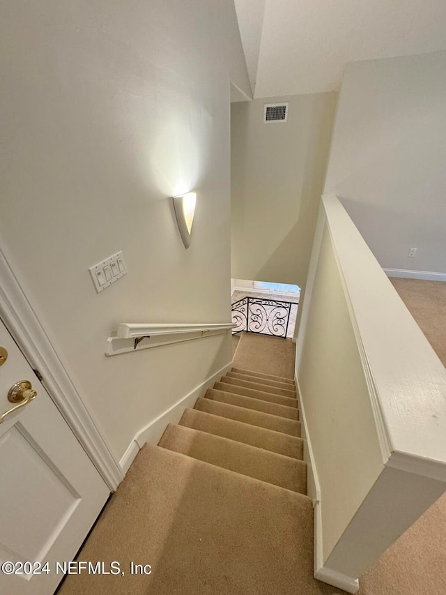 stairway featuring carpet