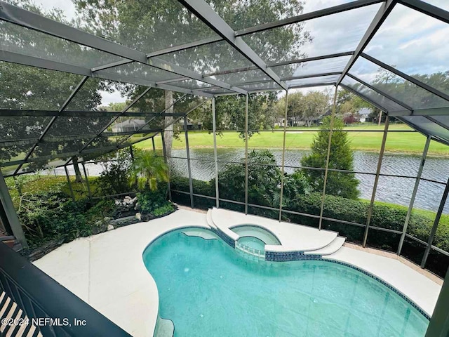 view of pool with a lanai, a patio area, a water view, and an in ground hot tub