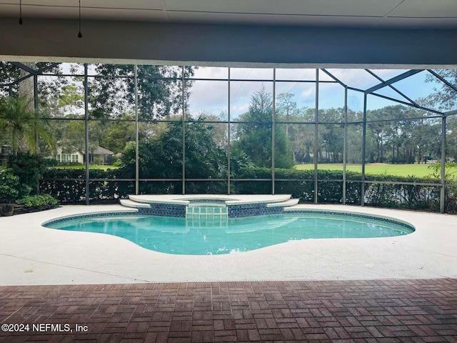 view of swimming pool with an in ground hot tub, a patio, and glass enclosure