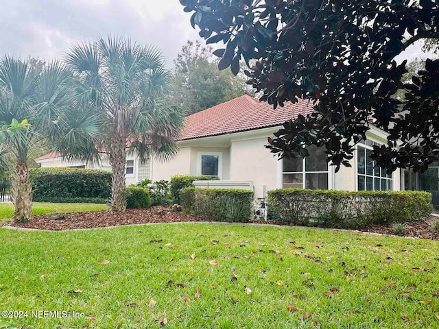 view of side of home with a yard