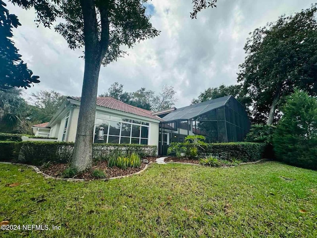 back of property featuring a yard and a lanai