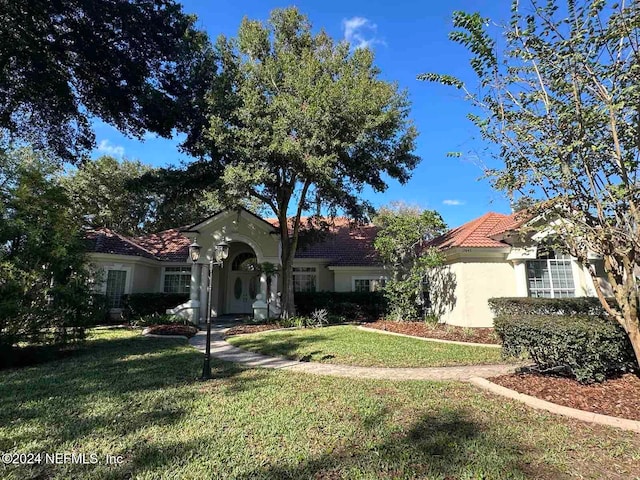 mediterranean / spanish-style house featuring a front yard