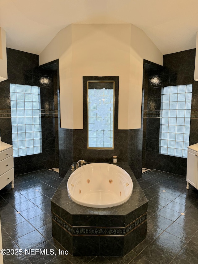 bathroom featuring lofted ceiling, plus walk in shower, vanity, and tile walls