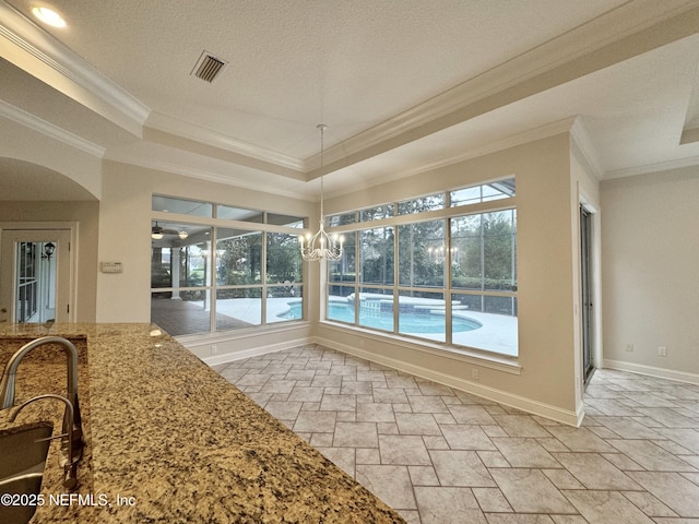 sunroom / solarium featuring a tray ceiling and sink