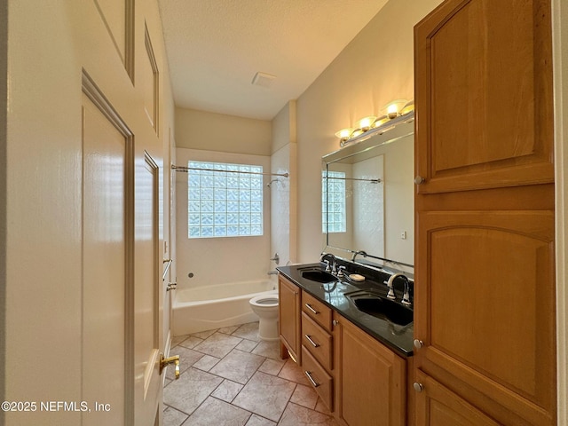 full bathroom featuring vanity, tiled shower / bath, a textured ceiling, and toilet