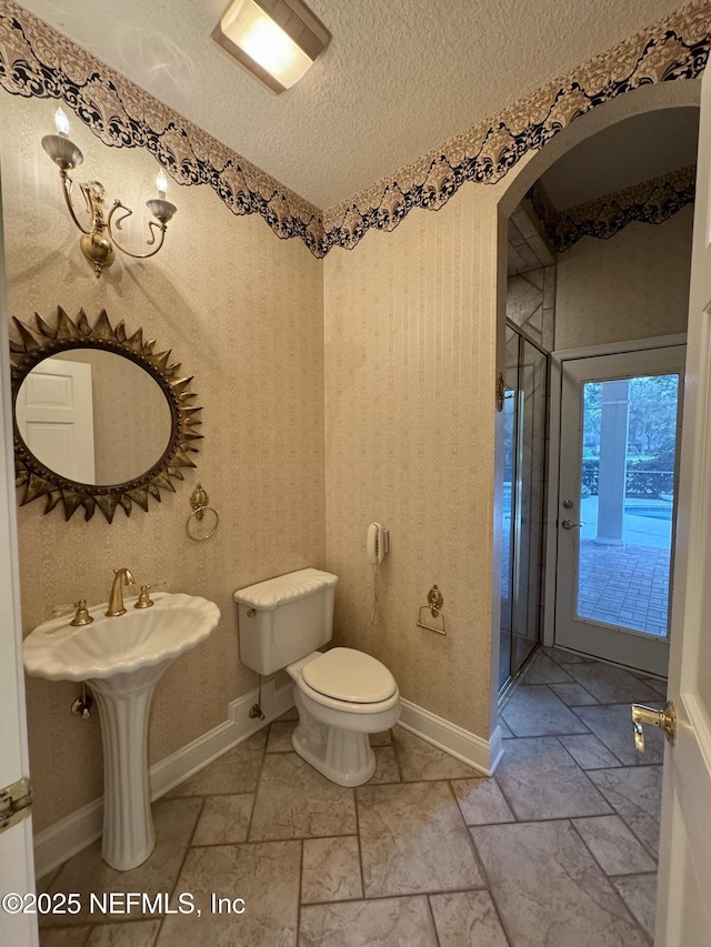 bathroom with toilet, sink, and a textured ceiling