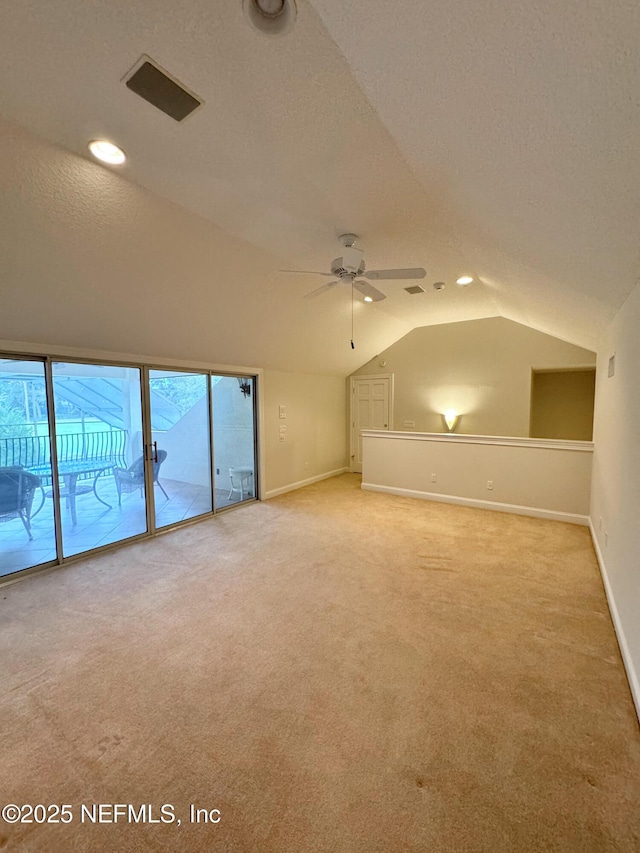 bonus room featuring ceiling fan, vaulted ceiling, light colored carpet, and a textured ceiling