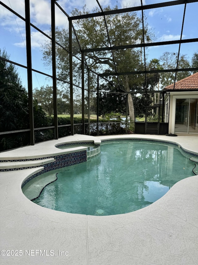 view of swimming pool featuring an in ground hot tub, a lanai, and a patio area