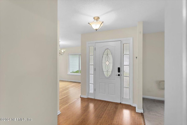 entryway featuring hardwood / wood-style flooring and a chandelier