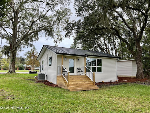 view of front of house with a front lawn and cooling unit