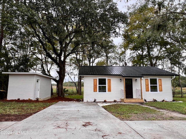 view of front of property featuring a shed