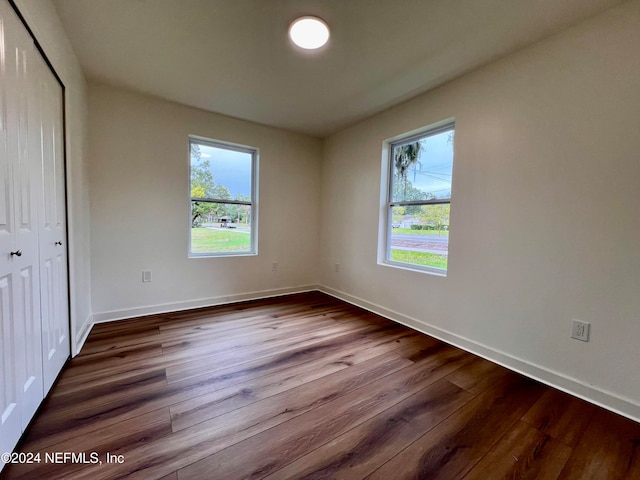 unfurnished bedroom featuring wood-type flooring and a closet