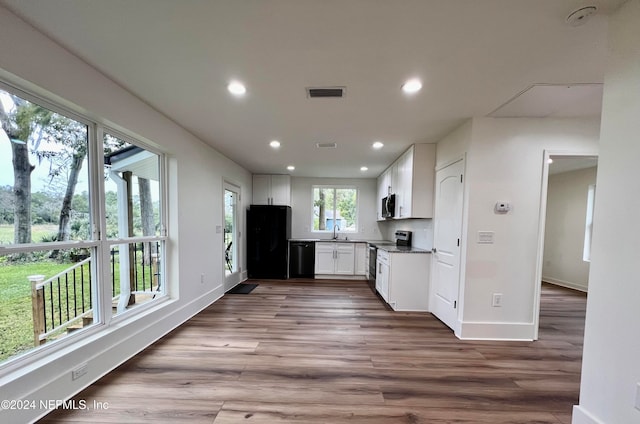 kitchen featuring white cabinets, sink, black appliances, and hardwood / wood-style floors