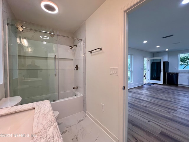 full bathroom featuring toilet, vanity, bath / shower combo with glass door, and wood-type flooring