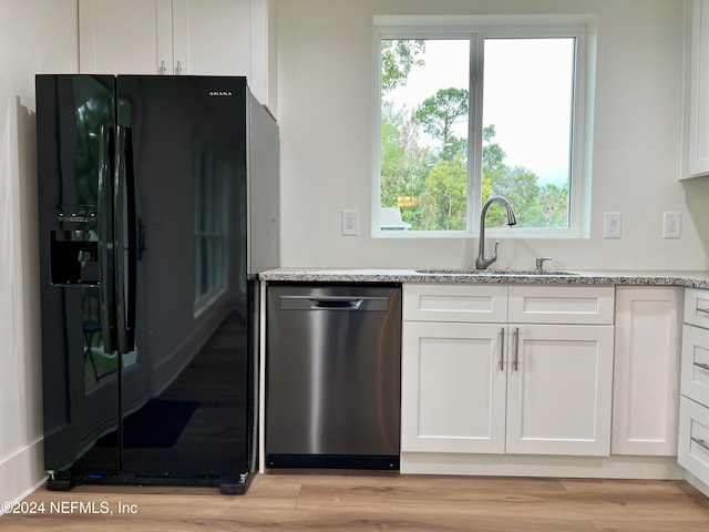 kitchen featuring stainless steel dishwasher, black refrigerator with ice dispenser, sink, and white cabinets