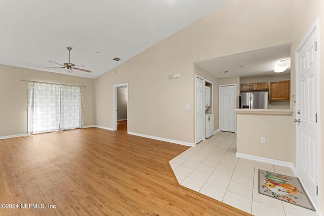 unfurnished living room featuring light hardwood / wood-style floors, ceiling fan, and vaulted ceiling