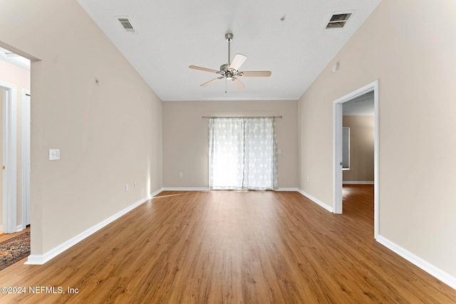 empty room with ceiling fan, wood-type flooring, and vaulted ceiling