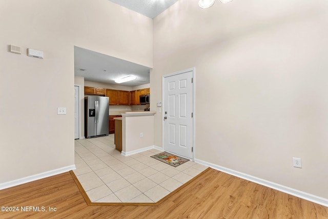 kitchen featuring light wood-type flooring, stainless steel appliances, and kitchen peninsula