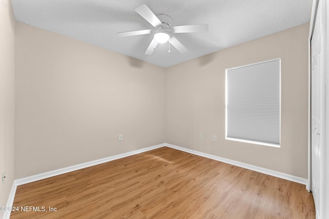 unfurnished room with a textured ceiling, light hardwood / wood-style flooring, and ceiling fan