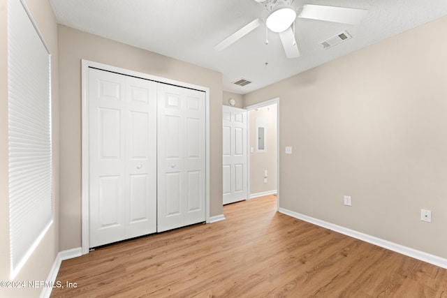 unfurnished bedroom featuring ceiling fan, a closet, and light wood-type flooring