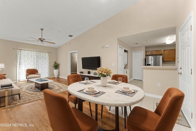 dining space featuring ceiling fan, vaulted ceiling, and light hardwood / wood-style floors