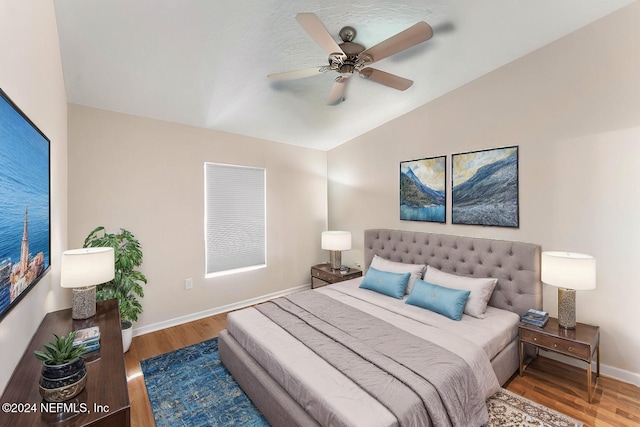 bedroom featuring hardwood / wood-style floors, ceiling fan, and lofted ceiling