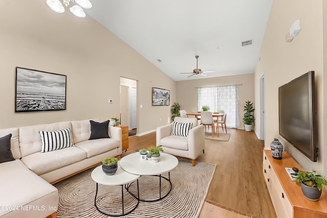 living room featuring light wood-type flooring, ceiling fan, and high vaulted ceiling