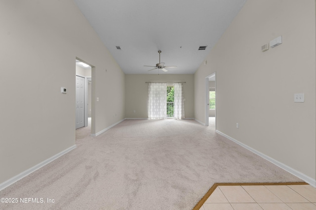 spare room featuring light colored carpet, ceiling fan, baseboards, and high vaulted ceiling