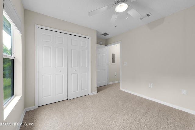 unfurnished bedroom with carpet, a closet, baseboards, and a ceiling fan