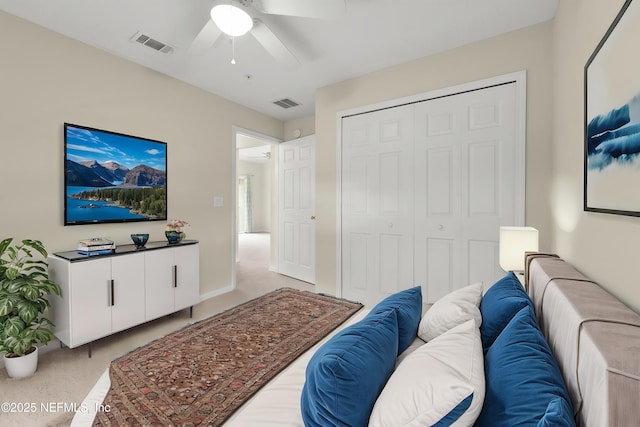 bedroom featuring light carpet, a closet, and a ceiling fan