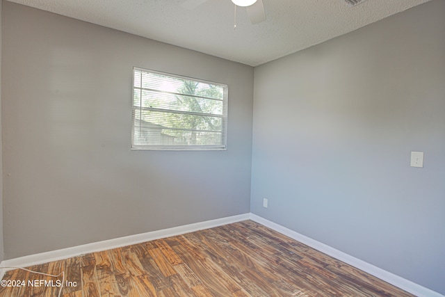 unfurnished room featuring a textured ceiling, dark hardwood / wood-style floors, and ceiling fan