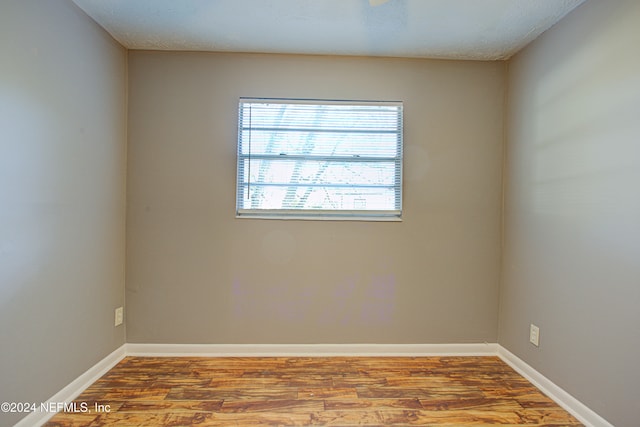 empty room featuring wood-type flooring and a textured ceiling