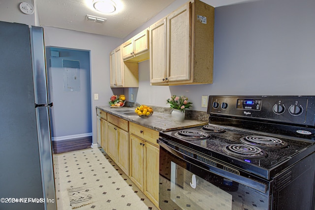 kitchen with stainless steel refrigerator, light brown cabinets, and black range with electric cooktop