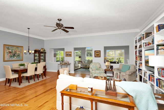 living room with ornamental molding, hardwood / wood-style floors, ceiling fan with notable chandelier, and a textured ceiling