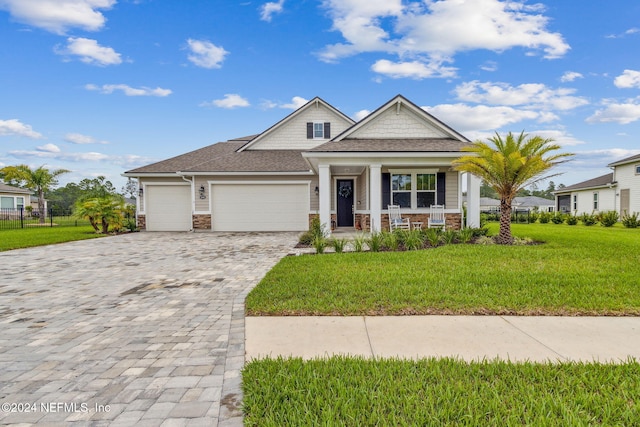 view of front of property featuring a porch, a front lawn, and a garage