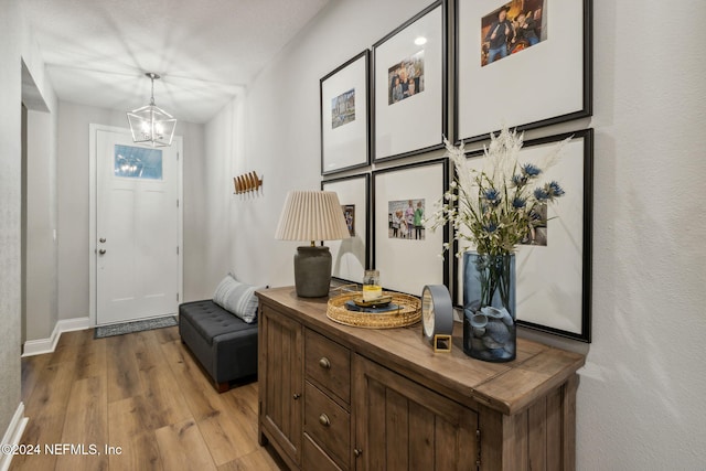 entryway featuring wood-type flooring and a notable chandelier