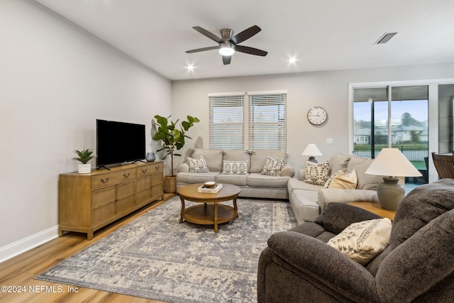 living room with a wealth of natural light, hardwood / wood-style floors, and ceiling fan