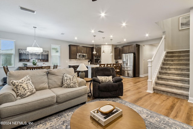 living room with light hardwood / wood-style flooring and an inviting chandelier