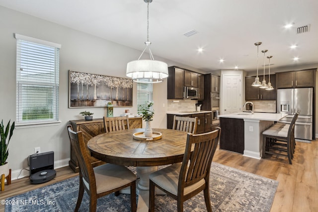 dining space featuring sink and light hardwood / wood-style flooring