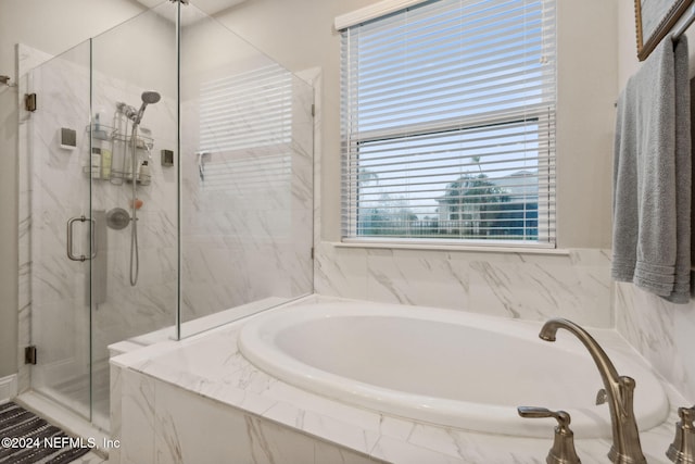 bathroom with shower with separate bathtub and plenty of natural light