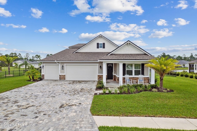 view of front of home with a front lawn, a garage, and covered porch