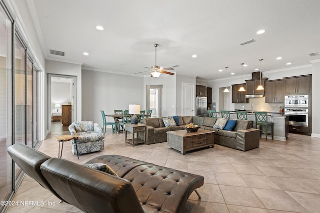 living room with ceiling fan, light tile patterned floors, and crown molding