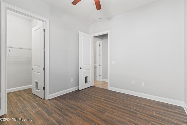 unfurnished bedroom featuring ceiling fan, a closet, and dark wood-type flooring