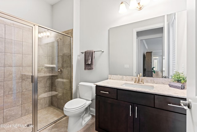 bathroom with tile patterned flooring, vanity, toilet, and walk in shower